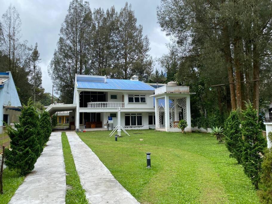 不拉士打宜Villa Berastagi Indah A32 - TEBU MANIS的蓝色屋顶和庭院的白色房子