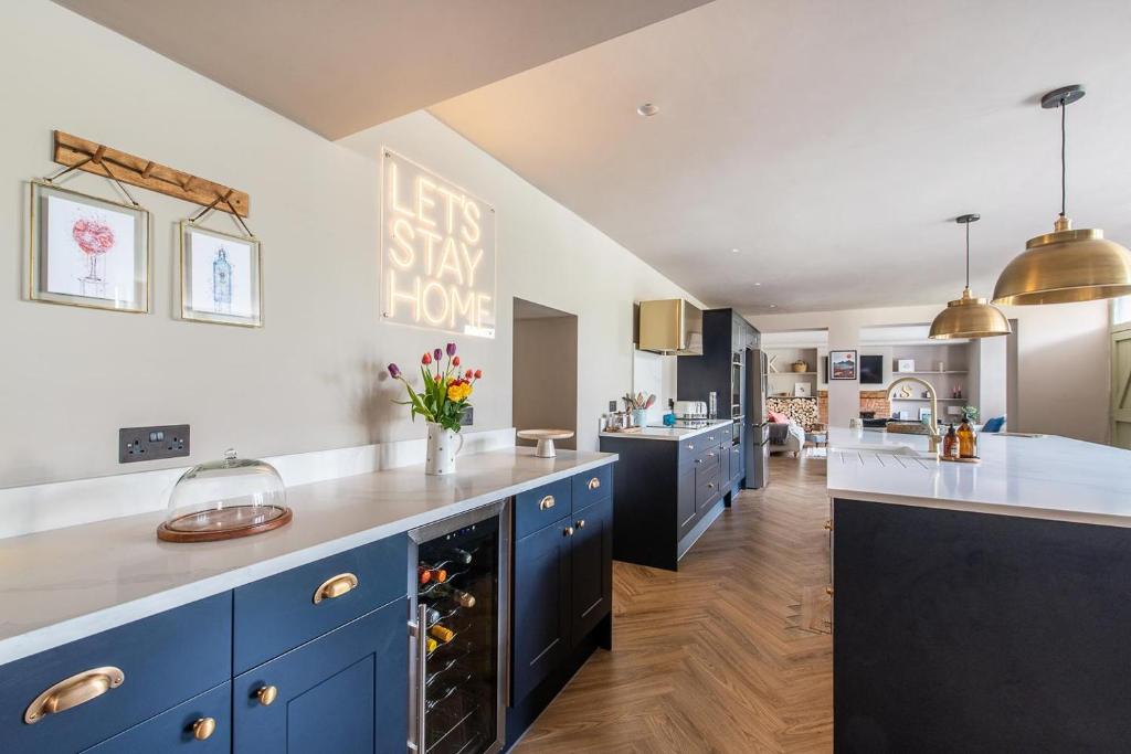 沃明斯特Immaculate 6 Bed House - Unique Cellar Bar- Airbnb的一间设有蓝色橱柜和白色台面的大厨房