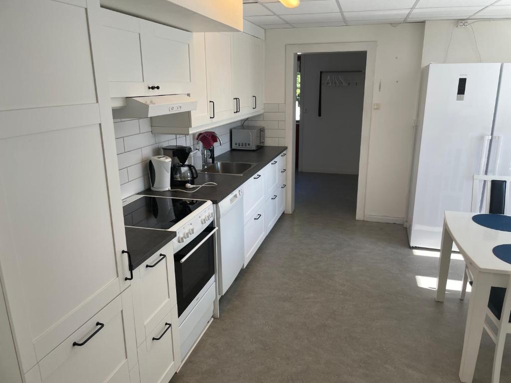 博伦厄Lärkan21 Tvisegatan 24C的白色的厨房设有水槽和炉灶。