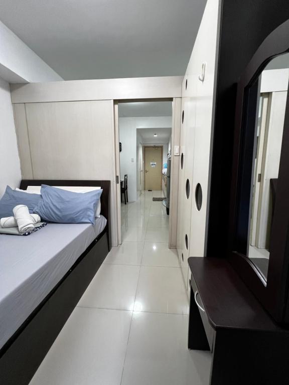 马尼拉Staycation Sea Residences MOA Jermel的一间小卧室,配有一张床和一个走廊