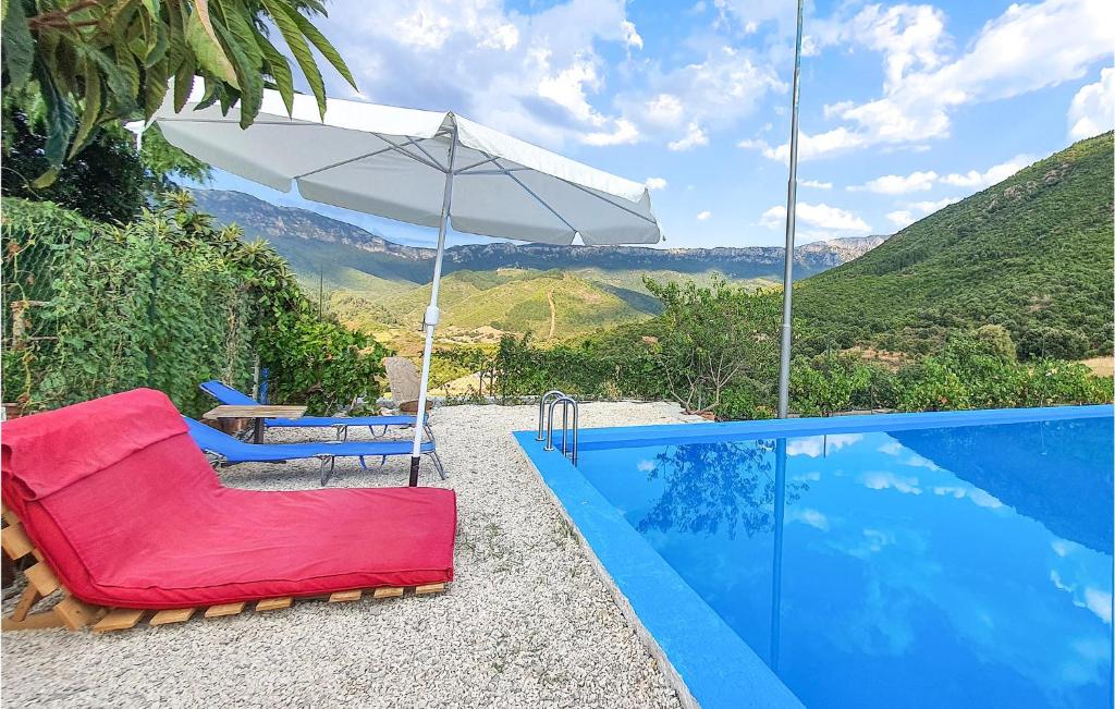 奥尔戈索洛Amazing Home In Orgosolo With House A Mountain View的游泳池旁的白色遮阳伞和椅子