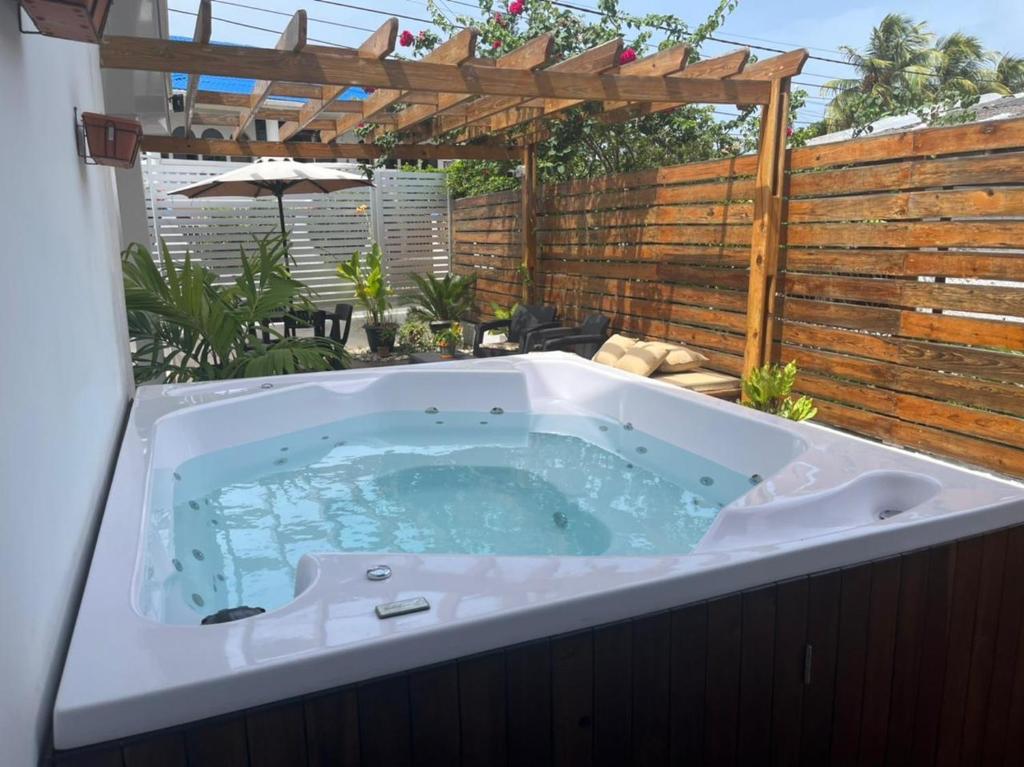 圣安德烈斯ATLANTIS CASA BOUTIQUE , con jacuzzi cerca de la playa的后院的按摩浴缸,带有木栅栏