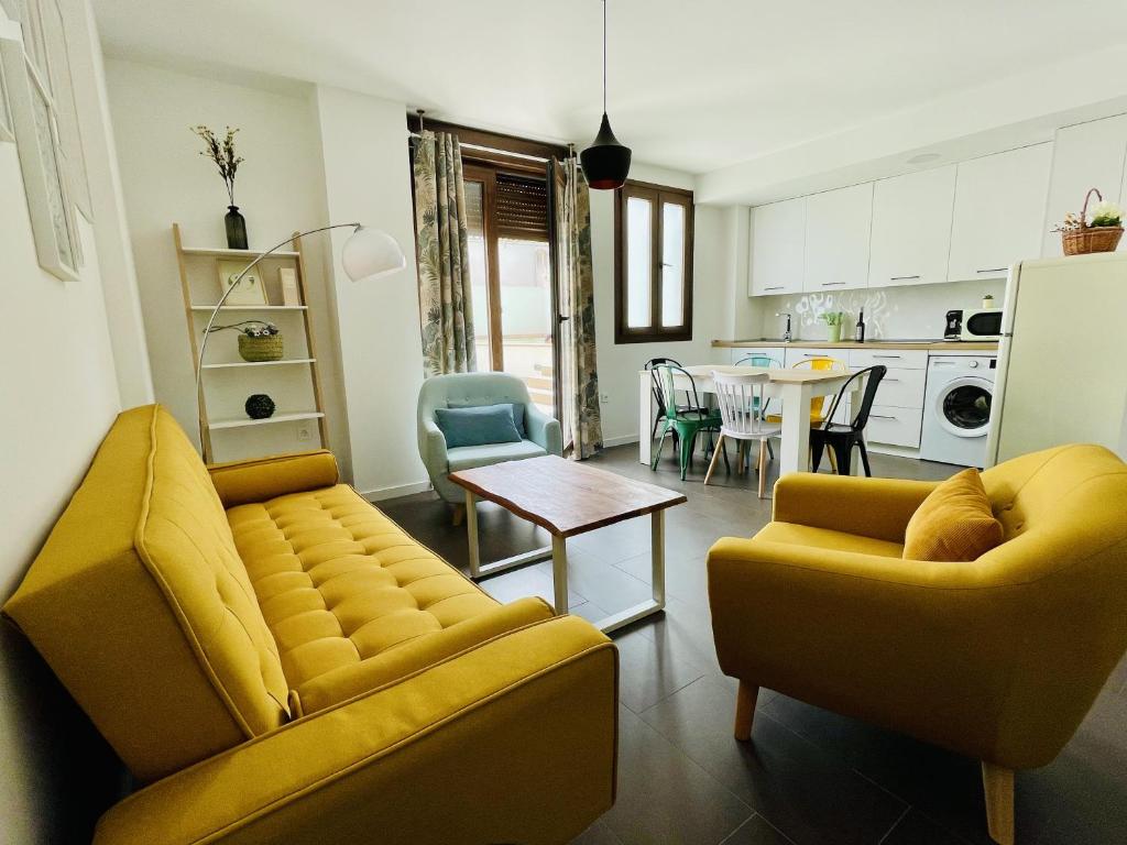 哈恩Coello 31的一间带两张黄色沙发的客厅和一间厨房