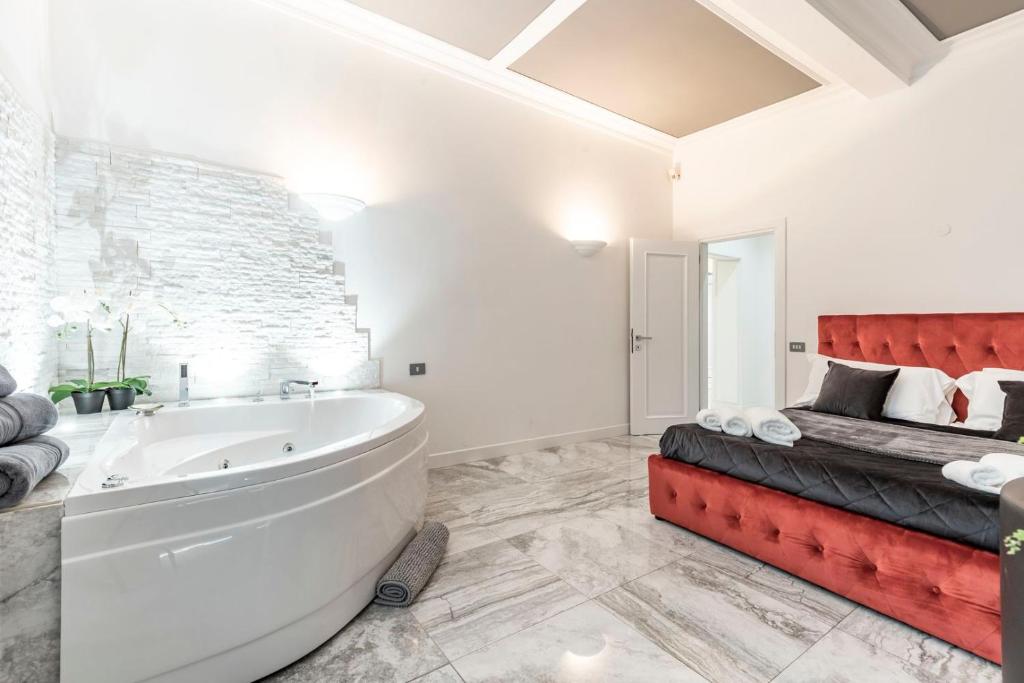 罗马Daphne Luxury Suites的白色的浴室设有浴缸和床。