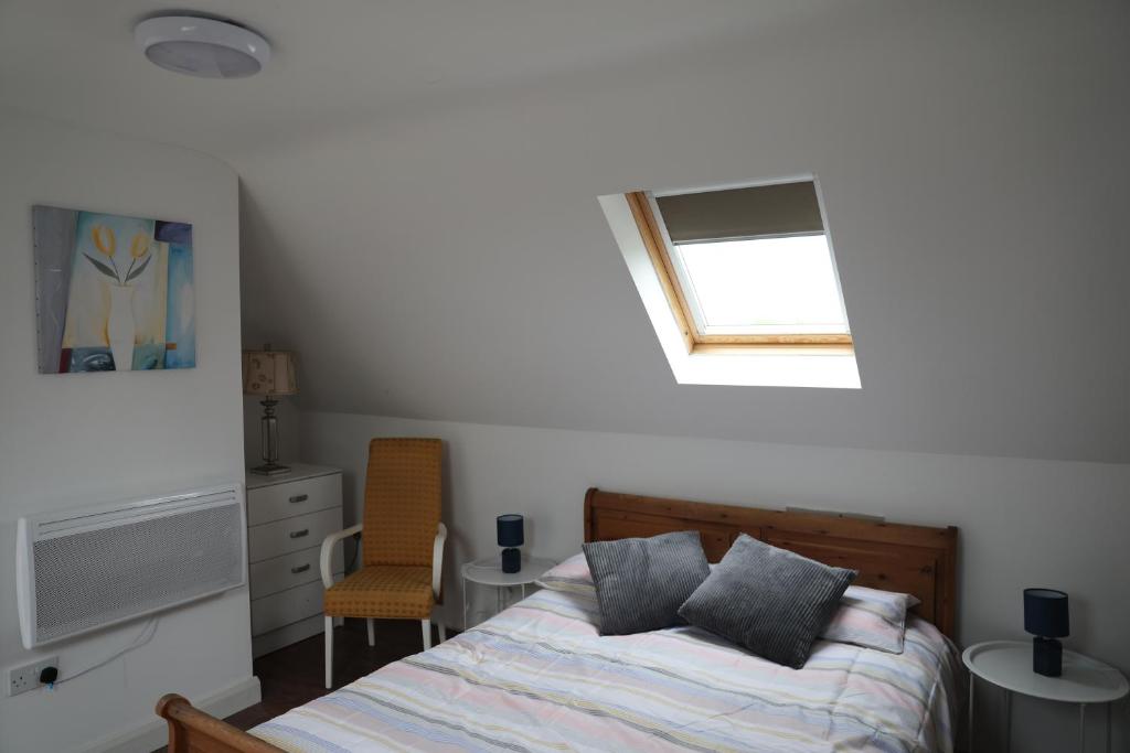 Cosy Loft situated on shores of Lough Neagh的一间卧室设有一张床和一个窗口