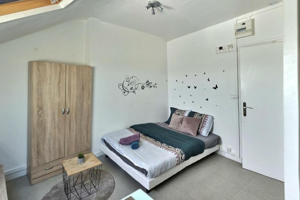 埃夫勒Le Lumineux Studio 6 Face Gare Wifi的一间卧室配有一张床和一个木制橱柜