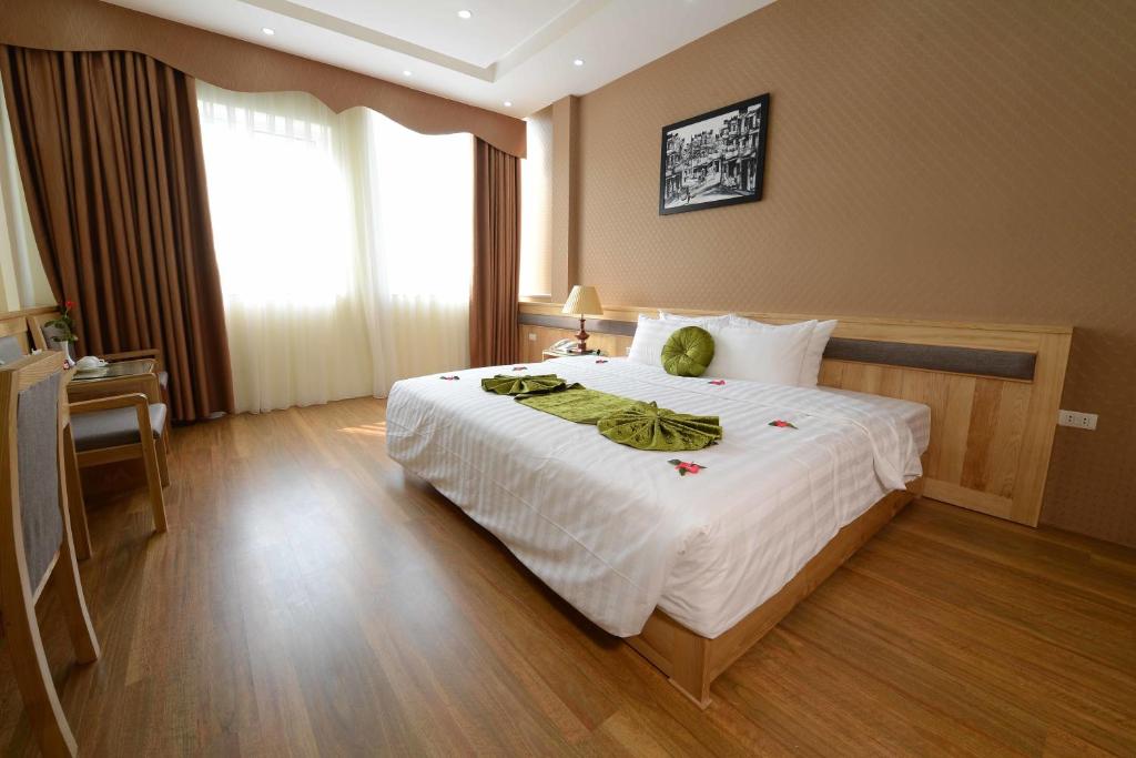 河内蓝河内宾馆的一间卧室配有一张大床,上面有泰迪熊
