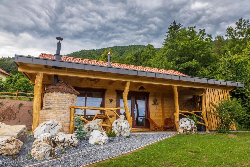 NazarjeLake Cottage - Koča ob jezeru的庭院内带石头壁炉的小木屋