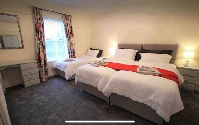 CullybackeyBallyconnelly Cottages, Galgorm area的酒店客房设有两张床和窗户。
