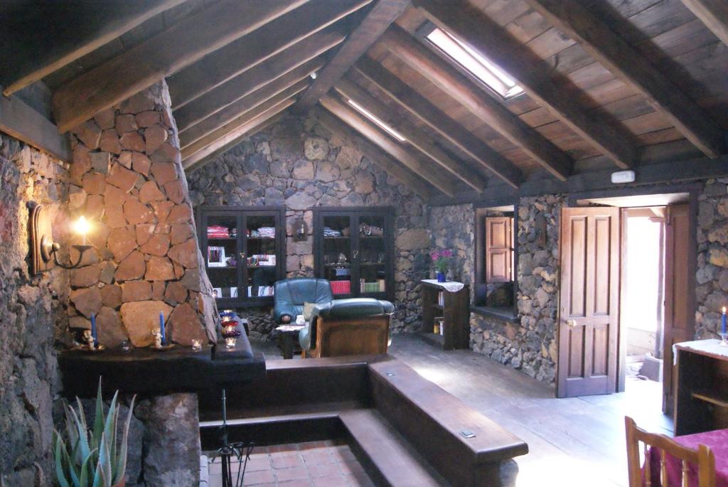 San Jose De Los Llanos卡塞里奥洛杉帕特多斯乡村民宿的客厅设有石墙和桌子