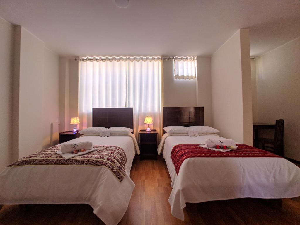 奇瓦伊Colca Canyon Hotel的酒店客房设有两张床和窗户。