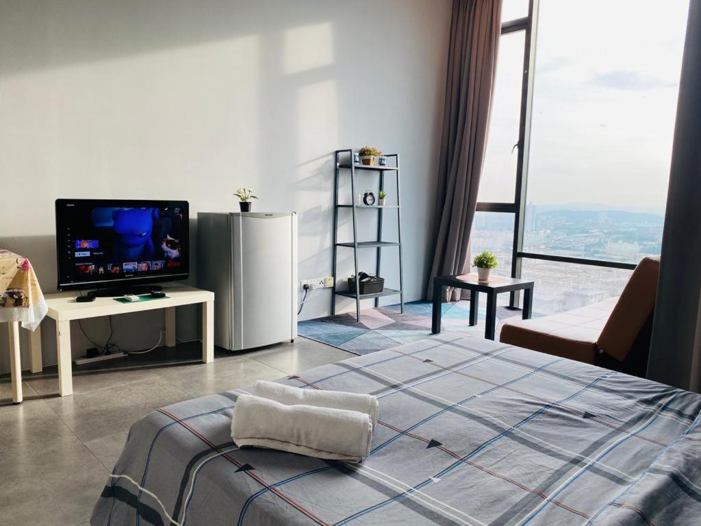 八打灵再也Miza Empire Damansara studio free wifi netflix的一间卧室设有一张床、一台电视和一个大窗户。