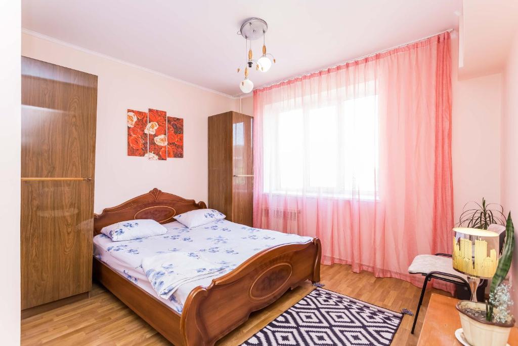 阿拉木图Двухкомнатная квартира Достык Омарова.的一间卧室设有一张床和一个窗口