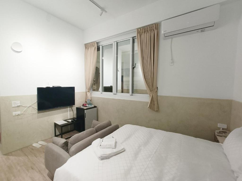 台南No 9 Hotel-九號文旅的一间卧室配有一张床、一张沙发和一台电视