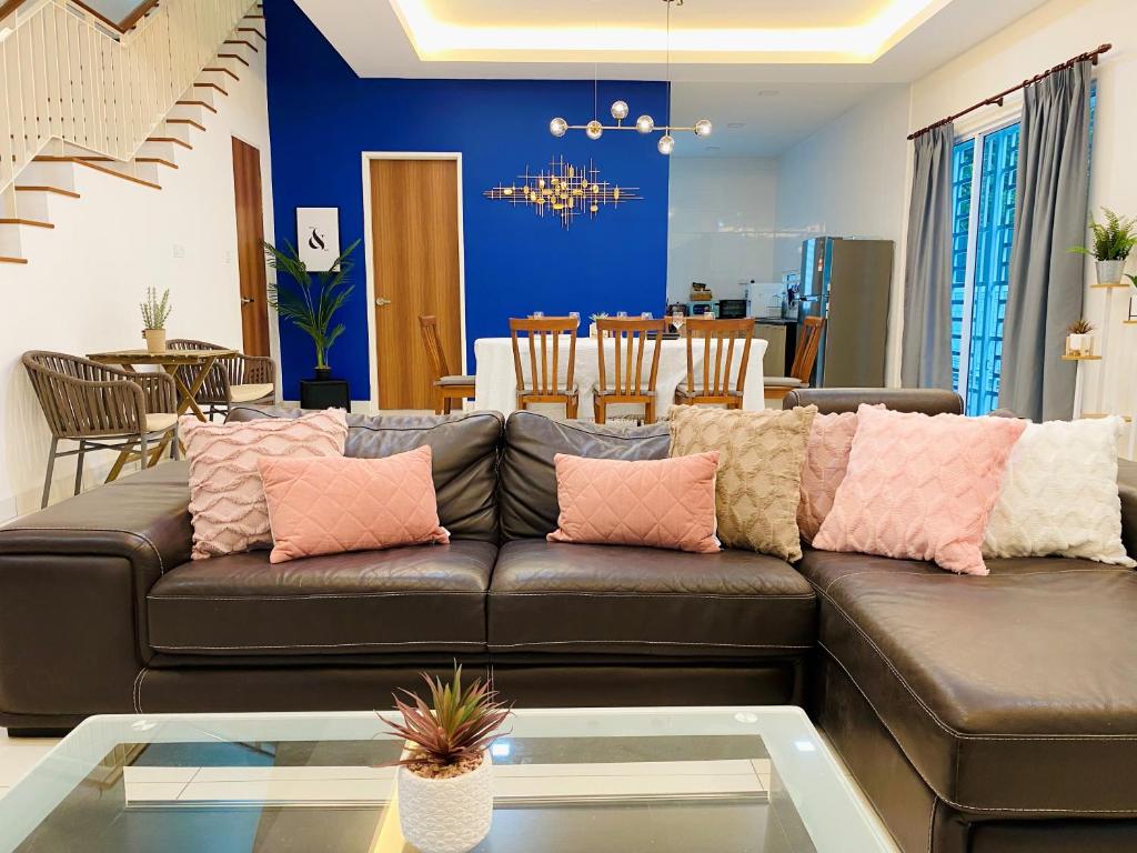 芙蓉5Bedroom Villa @ Seremban 20pax Netflix Projector Pool的客厅配有带粉红色枕头的棕色沙发