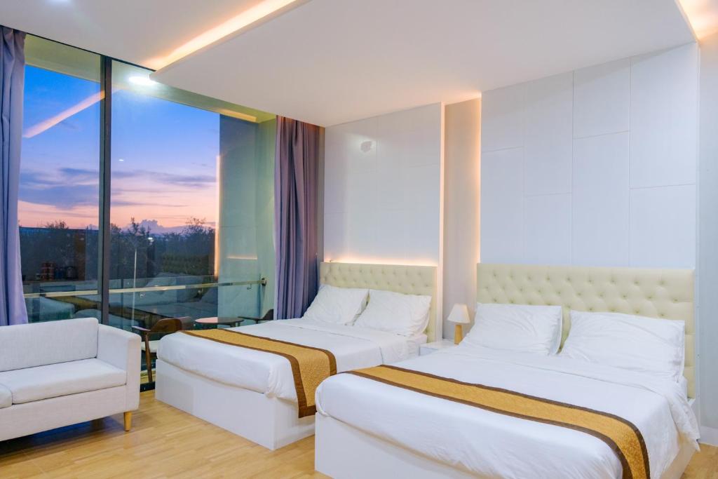 绥和市Khách sạn Minh Long的酒店客房设有两张床和窗户。