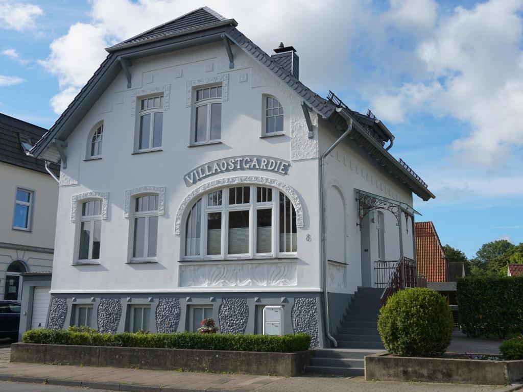 石勒苏益格Villa Ostgardie的白色的建筑,上面有标志