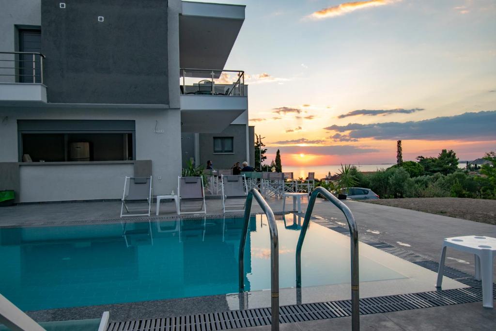 尼亚伊拉克利亚Heraclea Luxury Suites的一座房子,设有一座享有日落美景的游泳池