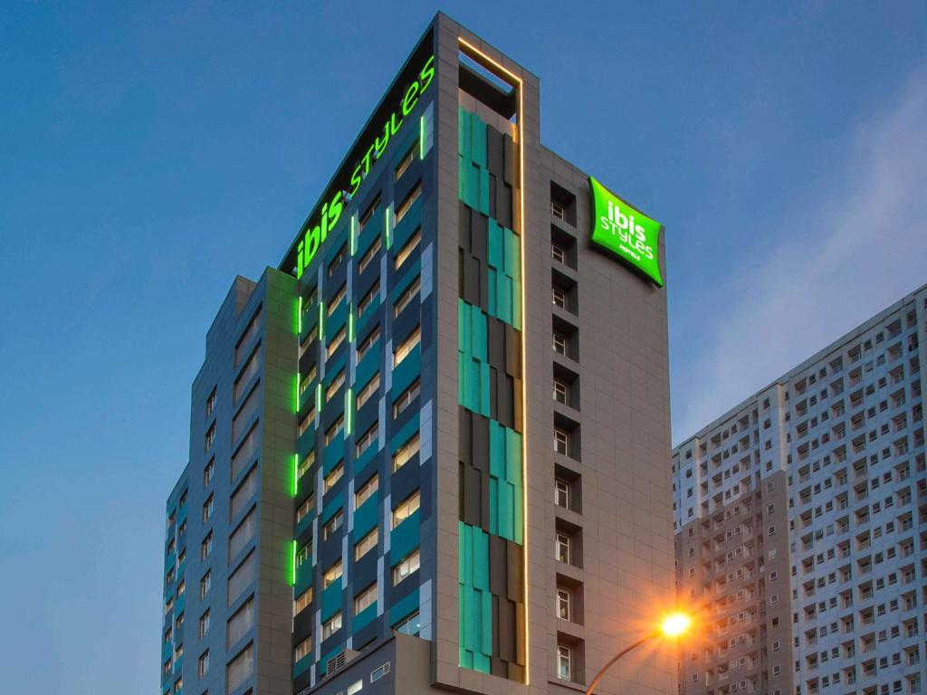 贝克西ibis Styles Bekasi Jatibening的上面有绿色标志的高楼