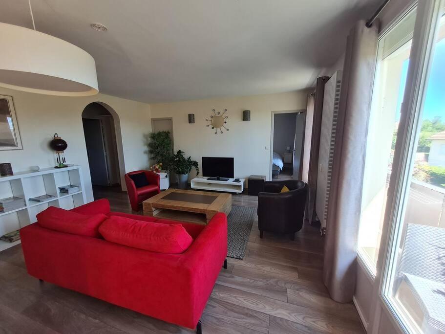 蓬托尔松Bel appartement tout proche du Mont st Michel的客厅配有红色的沙发和桌子