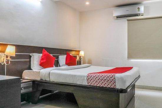 维沙卡帕特南The Padmavathi Guest House - Vizag的一间卧室配有一张带红色枕头的大床