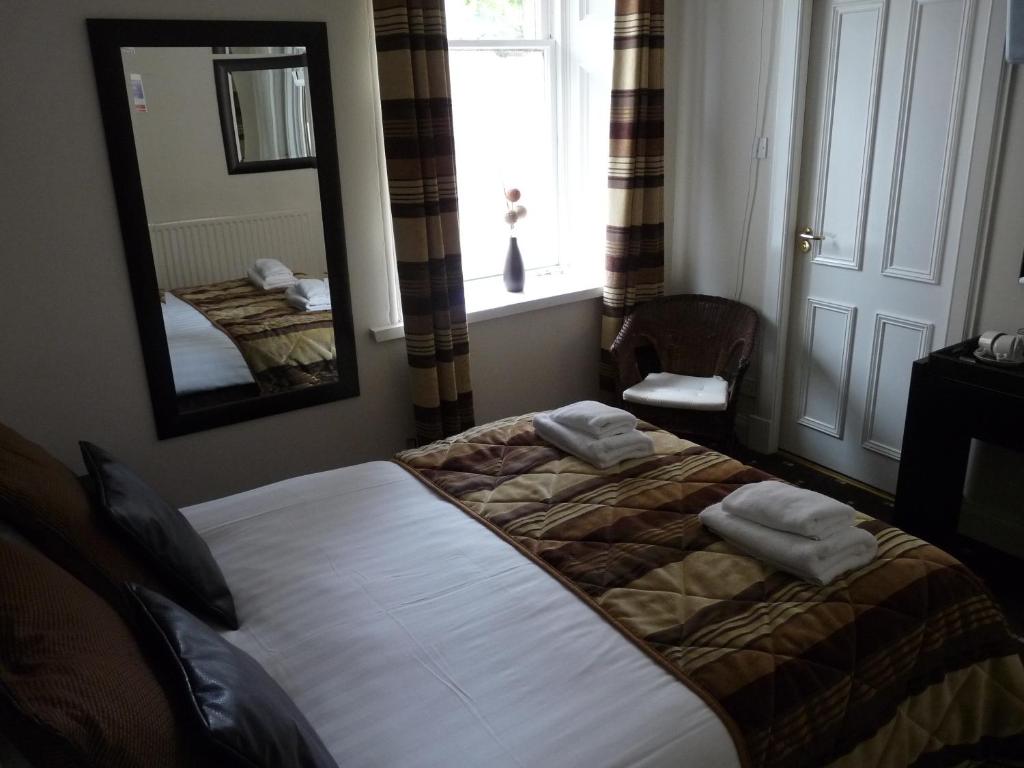 古罗克大三角帆酒店的一间卧室配有一张床、镜子和窗户