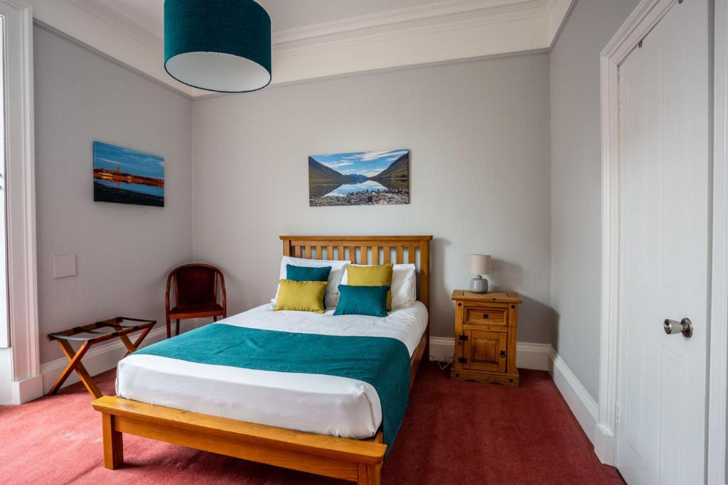 蒙特罗斯The Juniper Rooms的一间卧室配有蓝色和黄色枕头的床