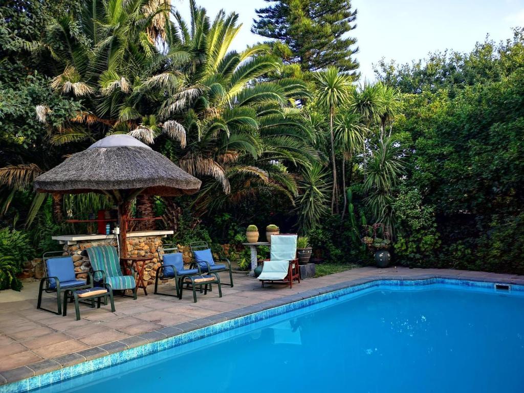 斯泰伦博斯Santika Villa Stellenbosch的游泳池旁设有椅子和凉亭