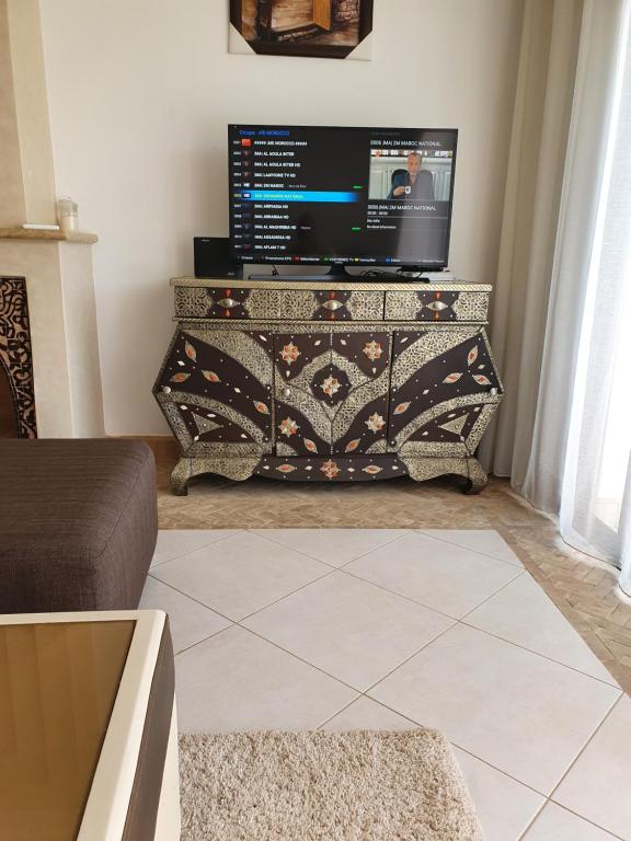 塔鲁丹特Superbe villa avec piscine privée的一间客厅,配有一张桌子上放的电视