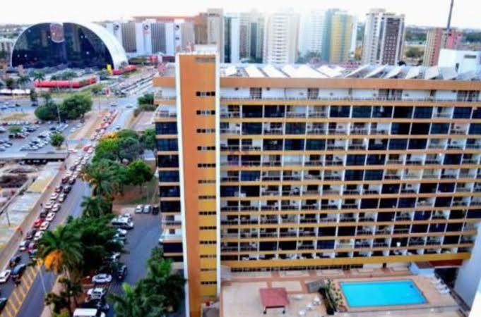 巴西利亚Apart Hotel em Brasília - MA Empreendimentos的一座大建筑,在城市前方设有游泳池