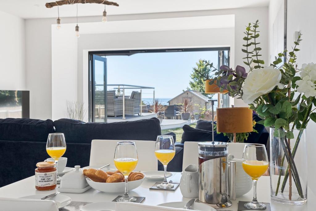 StokeinteignheadStunning Coastal Apartment in Maidencombe with Sea Views & Garden的一张桌子,上面放着酒和面包
