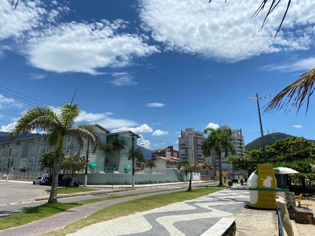 卡拉瓜塔图巴Desfrute bons momentos a beira mar com diária 24h的一条种有棕榈树和蓝天的街道
