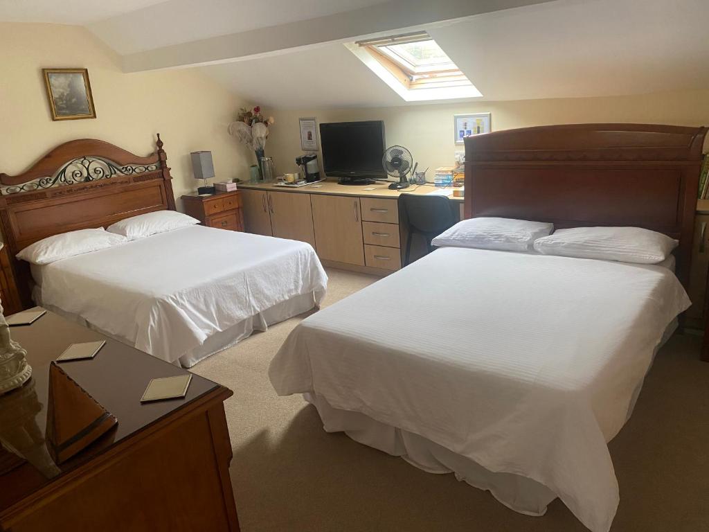 曼彻斯特Top of the House!的酒店客房设有两张床和电视。
