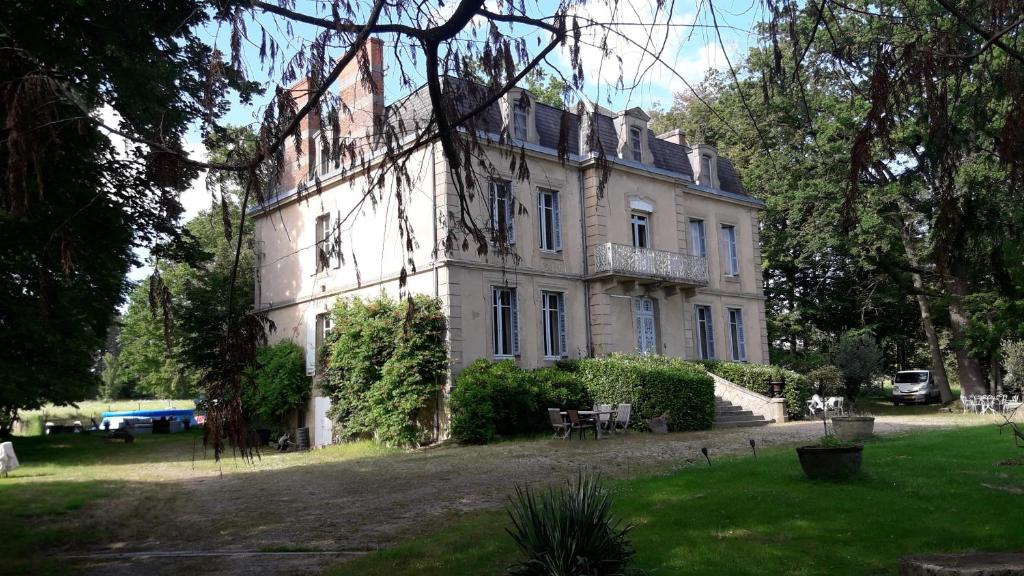 波旁拉尔尚博Chateau du Grand Lucay的前面有树木的白色大建筑