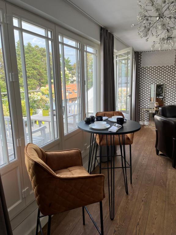 海斯特奥普登贝尔赫Rooftop terrace suite的客厅配有桌椅和窗户。