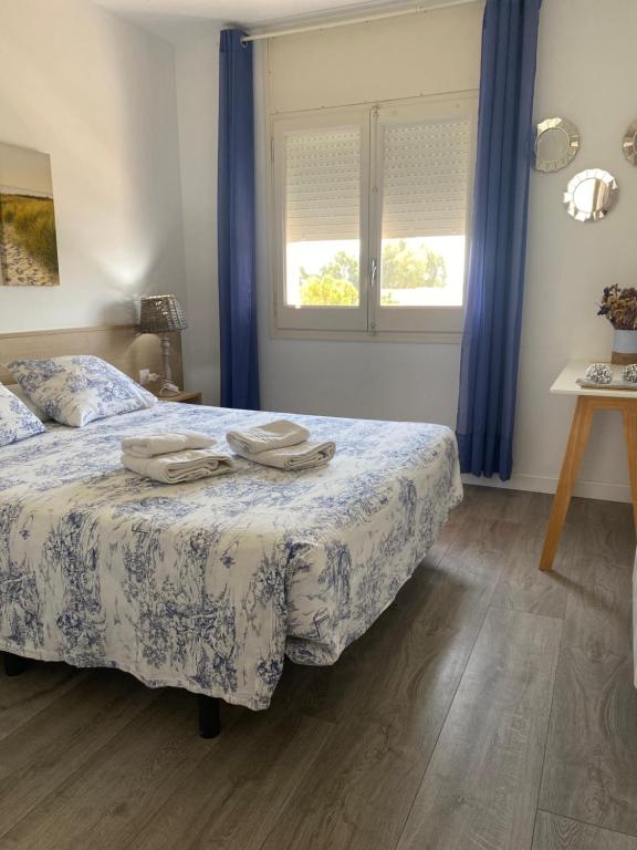 埃斯塔蒂特Apartamento Costa Brava的一间卧室配有床和蓝色窗帘的窗户