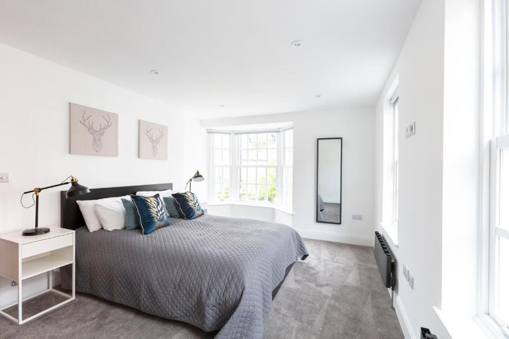 伊顿Hampden Apartments - The Louis的白色卧室配有床和镜子