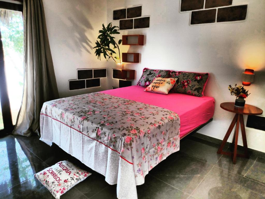 卡诺格布拉达Anacardium的一间卧室配有一张带粉红色床罩的床