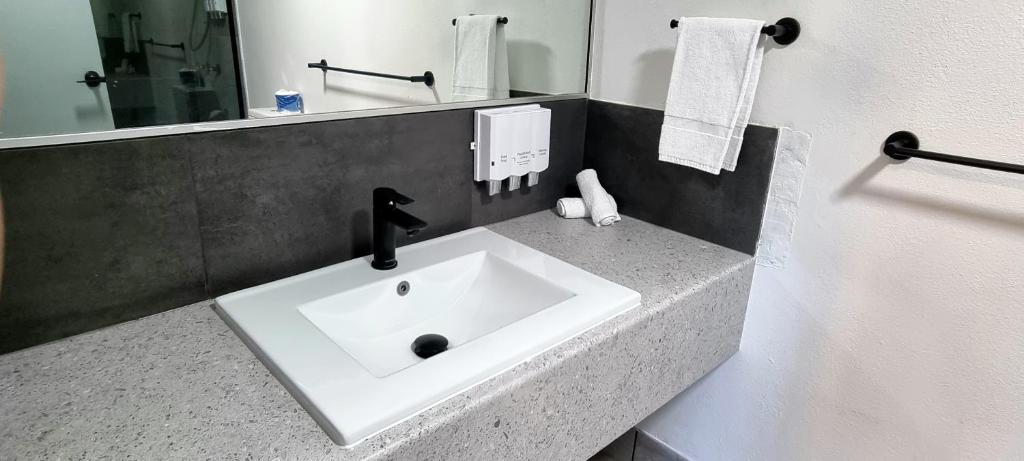 金皮Y Motels Gympie的浴室设有白色水槽和镜子