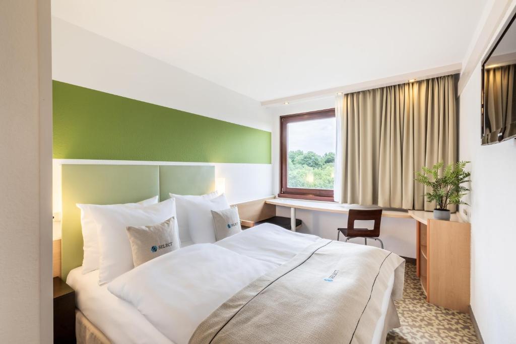奥斯纳布吕克奥斯纳布吕克精选酒店的酒店客房设有一张大床和一张书桌。