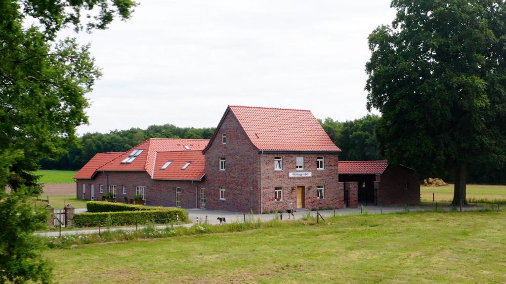 瓦森贝格Gitstapper Hof的两座砖砌建筑,在田野上设有红色屋顶