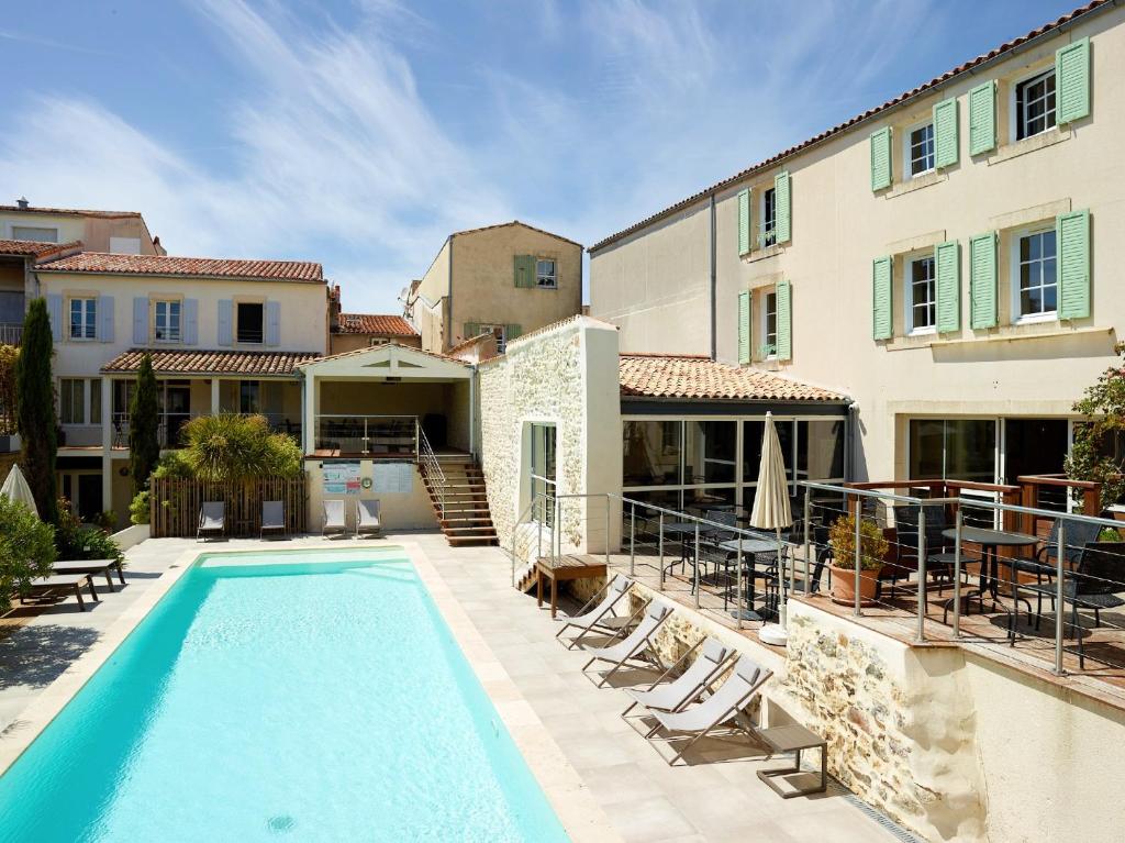 圣马丹德雷加里昂酒店的一座带房子的建筑前的游泳池
