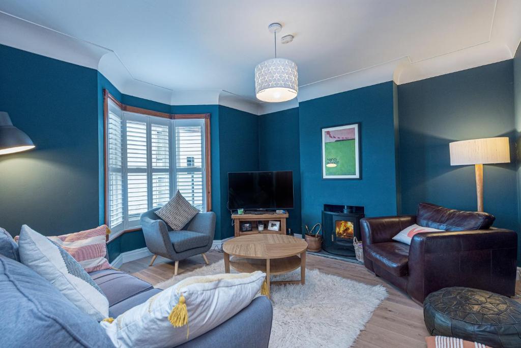 里辛Beautiful Redbrick Home in Ruthin Centre & Parking的蓝色的客厅配有沙发和桌子