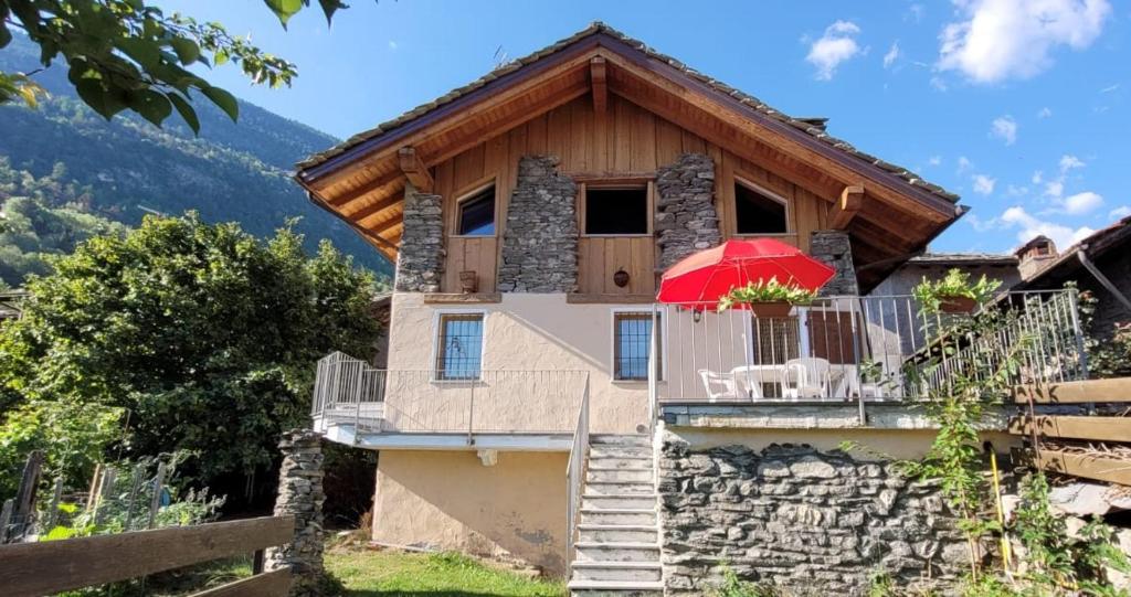艾马维尔Valle D'Aosta a 360° - Ideal for smart working的一个带红色遮阳伞阳台的房子