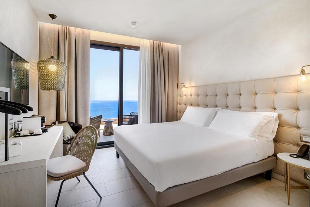 陶尔米纳Villa Fiorita Boutique Hotel的卧室配有一张白色大床和一张书桌
