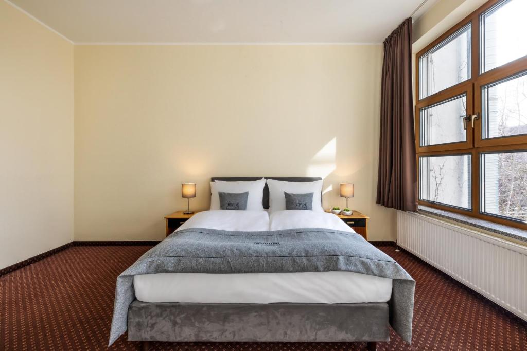 柏林Hotel City B Berlin Centrum的一间卧室设有一张大床和两个窗户