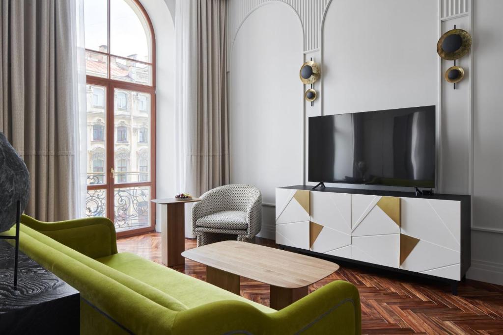 圣彼得堡Helvetia Hotel的客厅配有电视、沙发和桌子