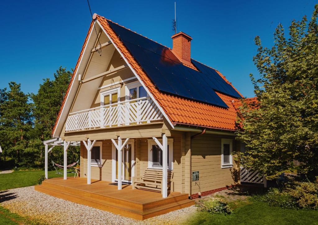 詹塔尔Dom pod Klonem的木甲板上设有太阳能屋顶的房子