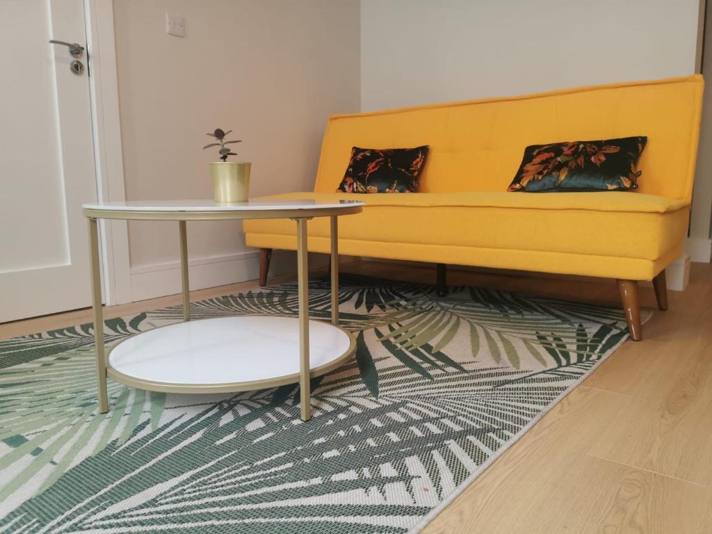 邓加文360 Town Stay Apartments & Studios的客厅配有黄色的沙发和桌子