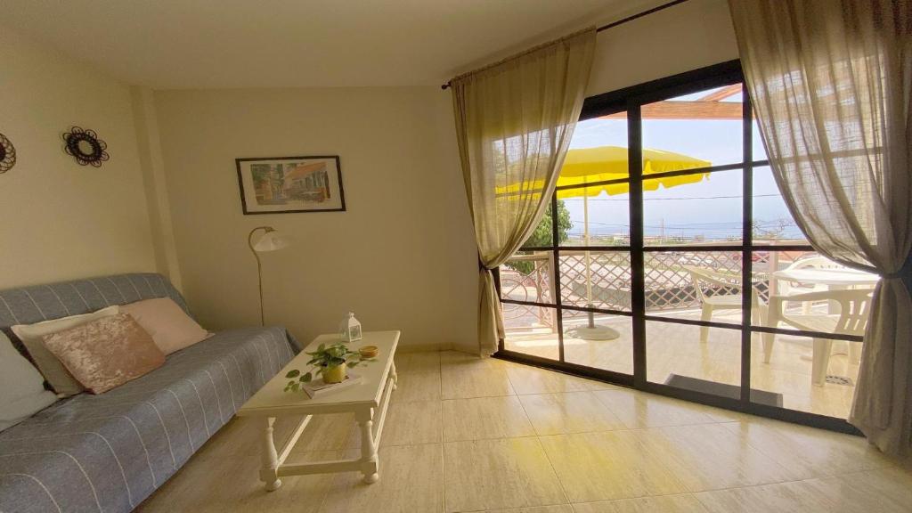 巴耶格兰雷伊La Tajea del Turno的带沙发和桌子的客厅以及阳台。